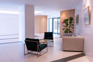 een lobby met 2 stoelen, een bank en een tafel bij Acqua Mar in Funchal