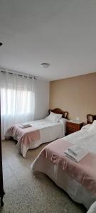 ein Schlafzimmer mit zwei Betten und einem Fenster in der Unterkunft Casa América in Labra