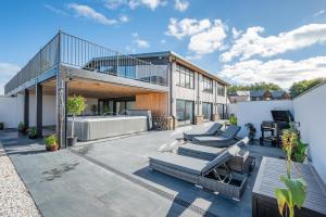 een patio met ligstoelen en een huis bij 12 Bed in Pancrasweek oc-lvbb24 in Pancrasweek