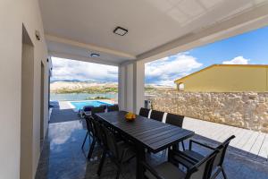 una sala da pranzo con tavolo e sedie su un patio di Villa Prestige a Pag