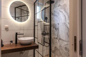 托隆Noma Suites Tolo的浴室配有洗手池和玻璃淋浴房