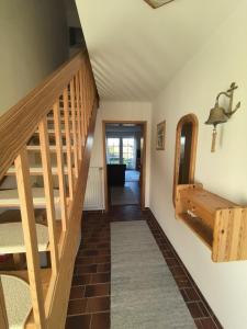 a hallway with a wooden staircase and a rug at Auszeit am Feldrand in Lensahn +29 photos