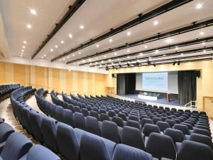 ein leerer Hörsaal mit blauen Stühlen und einer Leinwand in der Unterkunft Mercure Arras Centre Gare in Arras