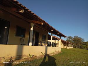 una casa con un prato accanto a un edificio di Pousada do macuco a São João Batista do Glória