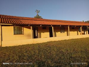 una casa gialla con tetto rosso e cortile di Pousada do macuco a São João Batista do Glória