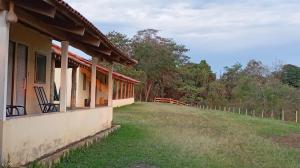 un edificio con una sedia sul lato di Pousada do macuco a São João Batista do Glória