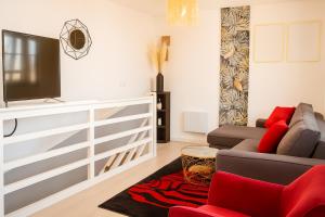 a living room with a couch and a tv at Résidence Peace in Le Bourget