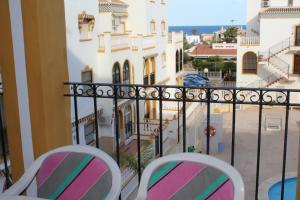 dwa krzesła na balkonie z widokiem na ulicę w obiekcie Molino Blanco w mieście Torrevieja