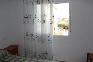 een slaapkamer met een raam met een bed en een gordijn bij Molino Blanco in Torrevieja