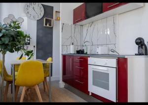 a kitchen with red cabinets and a table with a yellow chair at Résidence Peace in Le Bourget
