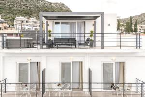 托隆Noma Suites Tolo的白色的房子,设有黑色栏杆阳台