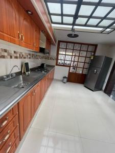 a kitchen with wooden cabinets and a stainless steel refrigerator at Hostal Otro Mundo in Pasto