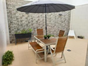 un tavolo e sedie con un ombrellone in un patio di Saudade Peniche Apartment a Peniche