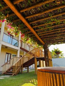 un pergolato in legno con una scala di fronte a un edificio di Pousada Solarium de Gostoso a São Miguel do Gostoso