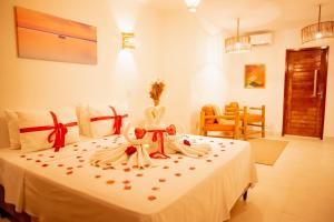 una camera da letto con un letto bianco con archi rossi di Pousada Solarium de Gostoso a São Miguel do Gostoso Altre 90 foto