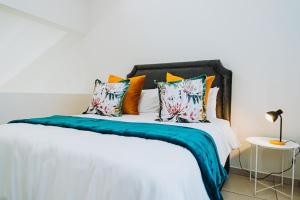 a bedroom with a white bed with colorful pillows at Modern Nest in Sandton