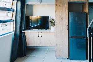 a kitchen with a sink and a refrigerator at Modern Nest in Sandton