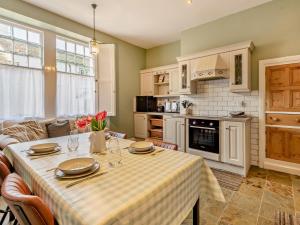 a kitchen with a table with plates and glasses on it at 2 Bed in Ambleside oc-95914 in Hawkshead