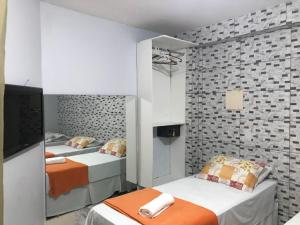 Un dormitorio con dos camas y un televisor de pantalla plana. en Pousada Bahia Morena, en Salvador