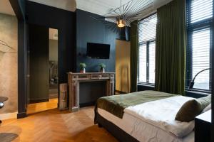 een slaapkamer met een bed, een open haard en een televisie bij Civiltà Boutique in Antwerpen