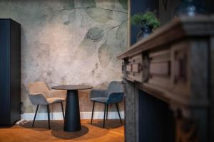 een tafel en stoelen in een kamer met een open haard bij Civiltà Boutique in Antwerpen