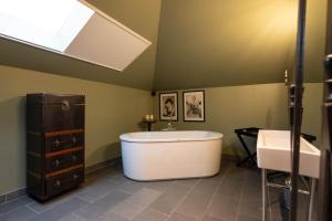 een grote badkamer met een bad en een wastafel bij Civiltà Boutique in Antwerpen