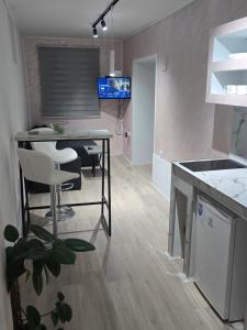 une cuisine avec une table et des chaises dans une pièce dans l'établissement Apartmani Lena, à Odžaci 2 autres photos