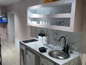 une cuisine avec un évier et un plan de travail dans l'établissement Apartmani Lena, à Odžaci