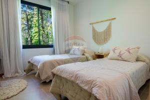 a bedroom with two beds and a window at Casa Calma Cariló in Carilo