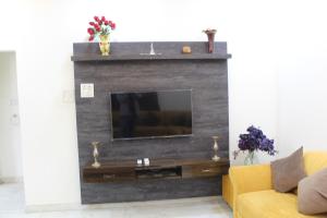 Rahath Home في حيدر أباد: غرفة معيشة بها أريكة صفراء وتلفزيون