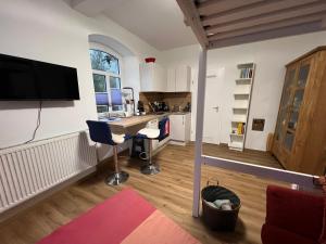 a kitchen and living room with a desk and chairs at Kleine Auszeit - Raum für Ruhe und neue Energie in Weidenberg