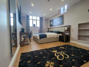 Schlafzimmer mit einem Bett und einem schwarzen Teppich in der Unterkunft Empress Boutique Hotel Suites in Mexborough