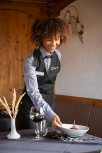 a woman standing at a table with a bowl of food at Alpen Hotel Vidi in Madonna di Campiglio +103 photos