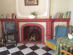 a living room with a brick fireplace and a tv at Ca Bienvenida in Miramar