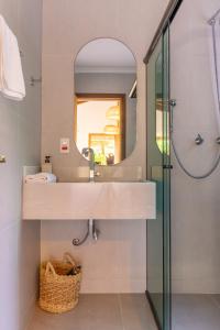 un bagno con lavandino e specchio di Pousada Marimar a Ilha do Mel Altre 109 foto