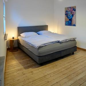 ein Schlafzimmer mit einem Bett und einem Gemälde an der Wand in der Unterkunft Altstadt Apartment Deluxe 2 in Haltern