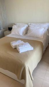 een bed met witte kussens en handdoeken erop bij Casa Rasiglia 2 in Casenove