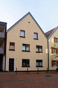 ein Gebäude mit Fenstern auf einer Backsteinstraße in der Unterkunft Altstadt Apartment Deluxe 2 in Haltern