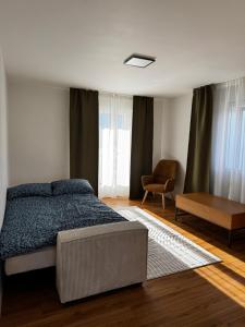 ein Schlafzimmer mit einem Bett und einem Stuhl in der Unterkunft Niesenblick apartment in Spiez