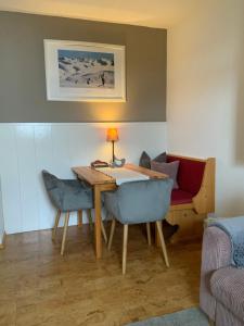 ein Esszimmer mit Tisch und Stühlen und einer Couch in der Unterkunft Anna's Appartement in Alpbach