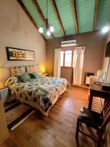 ein Schlafzimmer mit Bett, Schreibtisch und Fenster in der Unterkunft Posada Vientos de Belgrano in Villa General Belgrano