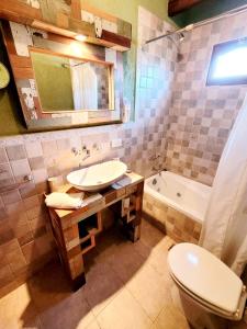 ein Badezimmer mit Waschbecken, Toilette und Badewanne in der Unterkunft Posada Vientos de Belgrano in Villa General Belgrano