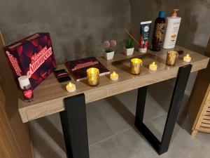 einen Tisch mit Kerzen und Flaschen Wein darauf in der Unterkunft Studio Glamour avec espace balnéo privé in Dallet + 10 Fotos