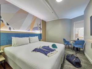 Una habitación de hotel con una cama, una mesa y sillas. en ibis Perth, en Perth 155 fotos más