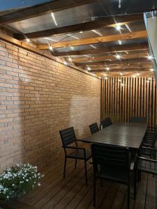 un patio con tavolo, sedie e muro di mattoni di Międzyleś 68  Altre 18 foto