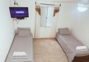 a room with two beds and a flat screen tv at Bungalow El Pini in Chajarí
