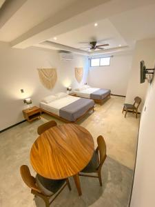 a bedroom with two beds and a table and chairs at Balam Suites in Playa del Carmen +86 photos