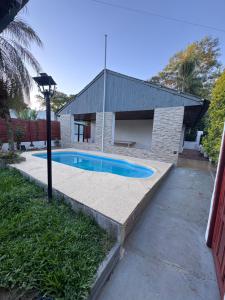 a swimming pool in front of a house at Alojamiento La Mamu 2 in Paso de la Patria