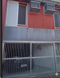 a building with a gate in front of it at Triplex no Centro e Pertinho da Praia in Guaratuba +1 photo