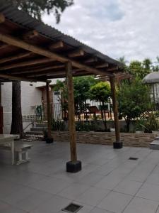 a wooden pergola on a patio in front of a building at Alojamiento La Mamu 1 in Paso de la Patria